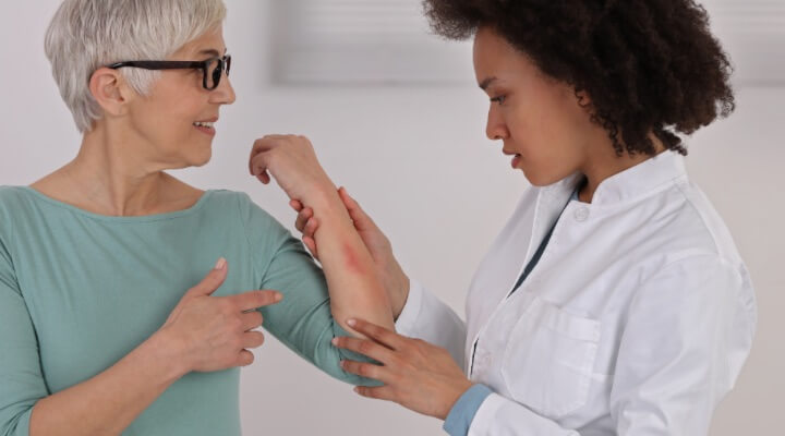 dermatologist inspecting arm